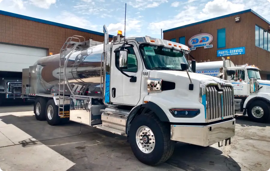 two fuel trucks in a row parked outside the building